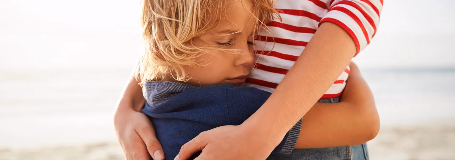 Kind in schützender Umarmung eines Elternteils nach Trennung - emotionaler Halt und Geborgenheit während Trennungsgespräch